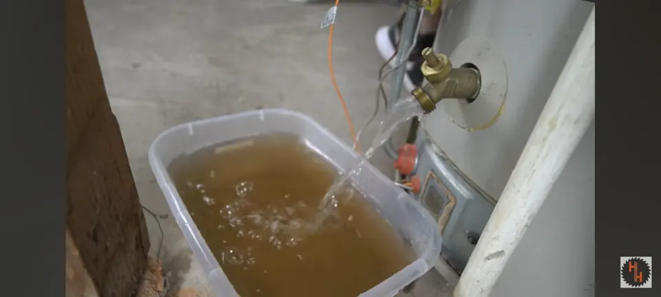 Water draining into a container beside a tank water heater